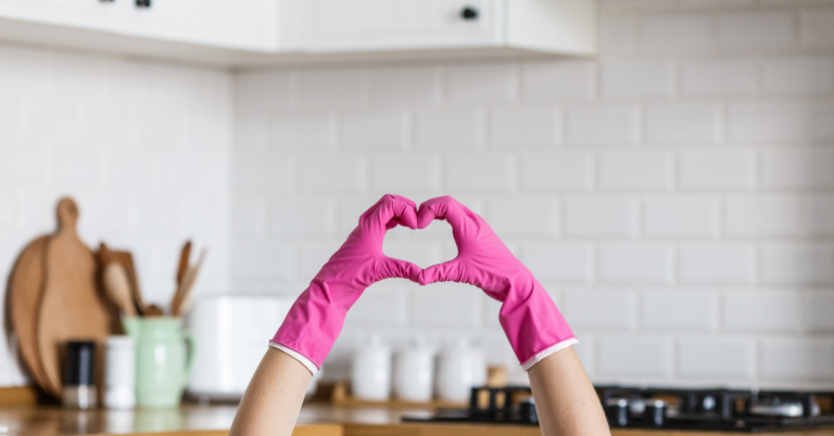 person making hearts with dishwashing gloves