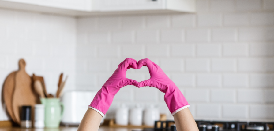 person making hearts with dishwashing gloves