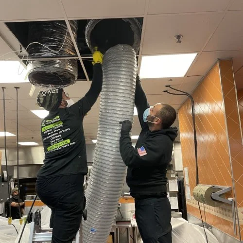Crew installing hose in ceiling