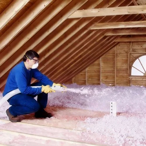 Worker installing pink insulation