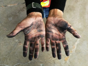 Hands covered in creosote from chimney cleaning