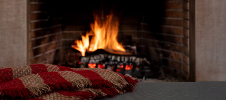 A blanket with a burning fireplace in the background