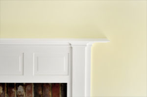 White fireplace mantel against yellow wall
